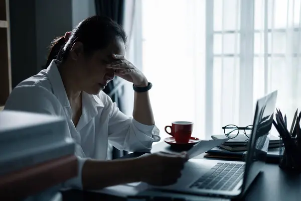 stock image Hard think on analysis in the work. Young asian business woman is working on pressure in office. Tired business woman sleepy and bored from sitting at a desk for a long time and has office syndrome.