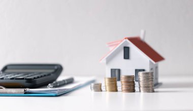 Paralı ev. Finans kavramı ya da gayrimenkul yeniden finanse etme. Evin sembolü dolarlarımızın arka planında duruyor. Emlak yatırımı. Ev kredisi oranı. Emeklilik için para biriktiriyorum.