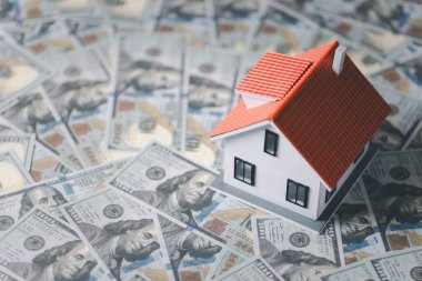 Evin faturası. Finans kavramı ya da gayrimenkul yeniden finanse etme. Evin sembolü dolarlarımızın arka planında duruyor. Emlak yatırımı. Ev kredisi oranı. Emeklilik için para biriktiriyorum