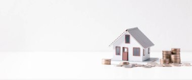 Paralı ev. Finans kavramı ya da gayrimenkul yeniden finanse etme. Evin sembolü dolarlarımızın arka planında duruyor. Emlak yatırımı. Ev kredisi oranı. Emeklilik için para biriktiriyorum.