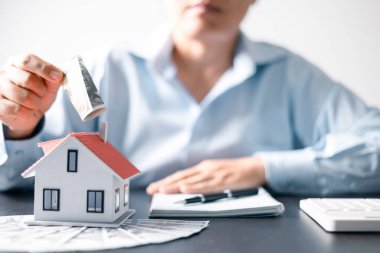 Paralı ev. Finans kavramı ya da gayrimenkul yeniden finanse etme. Evin sembolü dolarlarımızın arka planında duruyor. Emlak yatırımı. Ev kredisi oranı. Emeklilik için para biriktiriyorum.