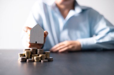 Paralı ev. Finans kavramı ya da gayrimenkul yeniden finanse etme. Evin sembolü dolarlarımızın arka planında duruyor. Emlak yatırımı. Ev kredisi oranı. Emeklilik için para biriktiriyorum.