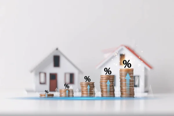 Percentage symbol for increasing interest rates on stacks of coins and model house. Interest rates increase, home loan, mortgage, house tax. investment and asset management concept. planning finance
