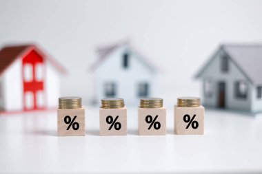 Yüzde ikonlu blok yığınından yüzde işareti olan el ele tutuşan ev simgesi. Ev ve mülk yatırımları ve varlık yönetimi kavramı. Faiz oranları, kredi kredisi, ev vergisi.