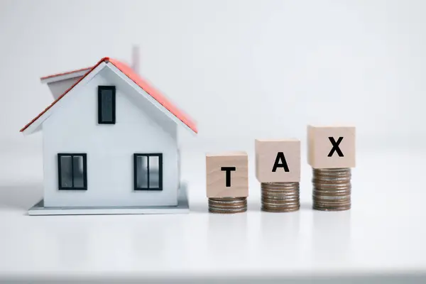 Concept of paying state property tax. Property Tax Wooden Blocks With A Miniature House. house model, mortgage loading real estate property with loan money bank concept.Home sales and home insurance