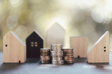 Ev modeli ve madeni paralar ahşap masanın üzerinde. Ev için para biriktirme kavramı, emlak ipoteği, inşaat yatırımı, emlak faizi, banka kredisi, sigorta işi, finans, muhasebe