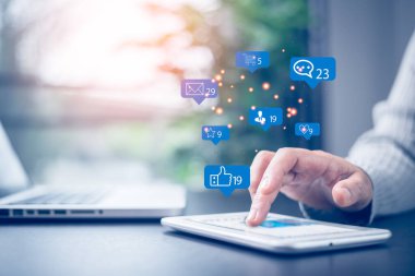 Sosyal medya ve dijital online konsept. Şirket ofisinde tabletle çalışan iş kadını, bildirim simgeleri ile, mesaj, yorum ve akıllı telefon ekranının üstünde yıldız gibi. Sosyal medya.