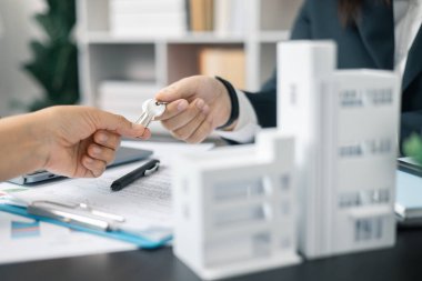 Emlakçı yeni evin anahtarını verdi, ister ev olsun ister apartman dairesi olsun, emlak işine başarılı bir yatırım yaptı. Emlakçı müşterilere evin anahtarını veriyor..