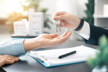Emlakçı yeni evin anahtarını verdi, ister ev olsun ister apartman dairesi olsun, emlak işine başarılı bir yatırım yaptı. Emlakçı müşterilere evin anahtarını veriyor..