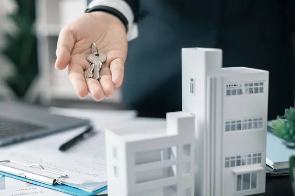 Emlakçı yeni evin anahtarını verdi, ister ev olsun ister apartman dairesi olsun, emlak işine başarılı bir yatırım yaptı. Emlakçı müşterilere evin anahtarını veriyor..