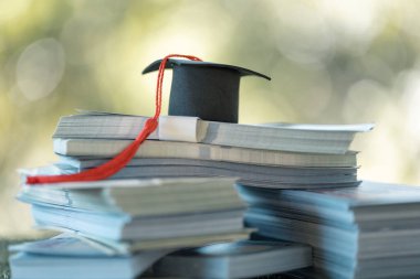 Üniversiteden mezun olup finans alanında üniversite mezunu olmak, yatırılan her madeni paranın değerini öngören başarılı bir eğitim başarısı anlamına geliyordu. Para, üniversite, eğitim, mezuniyet, şapka, okul.