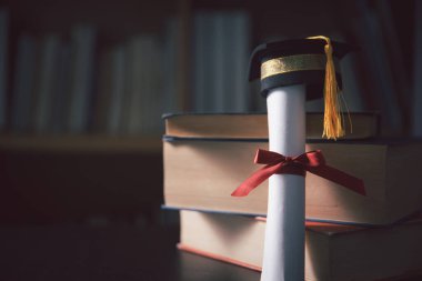 Mezuniyet töreninin arka planında, insanlar siyah şapkalarla süslenmiş yüksek öğrenim sertifikalarını alan öğrencilerin başarısını kutluyorlardı. eğitim, yüksek eğitim.