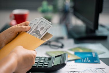 Kişi, gelecekteki ödemeler ve iş yatırımları için istikrarlı bir gelir sağlamak amacıyla maaşlarından tasarruf ederek finansmanı akıllıca yönetir. para, para, tasarruf, nakit, el, finans, finans, gelir.