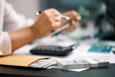 Kişi, gelecekteki ödemeler ve iş yatırımları için istikrarlı bir gelir sağlamak amacıyla maaşlarından tasarruf ederek finansmanı akıllıca yönetir. para, para, tasarruf, nakit, el, finans, finans, gelir.