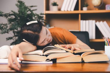 Asyalı kız ev ödevi yapıyor ve evde çalışıyor. Masa başında dizüstü bilgisayar kullanan bir kadın webinar izleyen, online çalışan, internet dersine giren ya da evden kumandalı sanal telefon görüşmesi yapan notlar yazıyor..