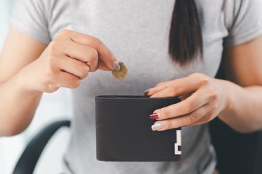 Genç Asyalı kadın yığınla para kazanıyor. Yatırım tasarruf konsepti, tasarruf, yatırım. Masada yığınla bozuk para ve banka hesap makinesi, tasarruf etmek için para ve gelir elde etmek için yatırım..