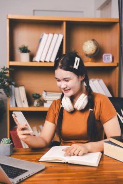 Uzak bir toplantıyla Asyalı ev okulu öğrencisi okul öğretmeninden sanal internet dersini öğreniyor. Kadın kulaklıkla matematik öğretiyor. Eğitim konsepti. Okulda bilgisayar eğitimi alan bir öğrenci.