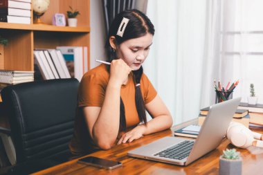 Uzak bir toplantıyla Asyalı ev okulu öğrencisi okul öğretmeninden sanal internet dersini öğreniyor. Kadın kulaklıkla matematik öğretiyor. Eğitim konsepti. Okulda bilgisayar eğitimi alan bir öğrenci.