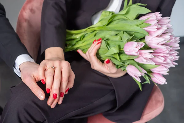 Engagement ring on woman\'s right hand. Couple wearing black suit