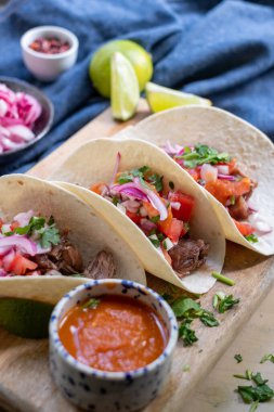 Taze sebzeli taze pişmiş tortilla. Kırmızı domates, marul, kırmızı lahana, limon suyu. Tahta bir tepside porselen mavi-beyaz bir tabakta domates sosu..