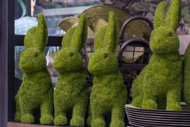 Eğlenceli, eğlenceli, büyük, yosun yeşili paskalya tavşanları, siyah sepet. Benekli bulanık arkaplan.