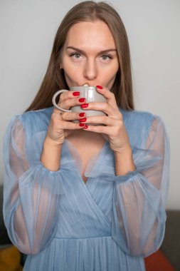 Açık mavi elbiseli, güzel genç bir kadın. 