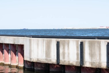 Denizde metal pembe borularla güçlendirilmiş beton yapı. Gökyüzü, gemi ve arka planda yüzen platform. Uzayı kopyala Alıntılar için arka plan. Yüksek kalite fotoğraf