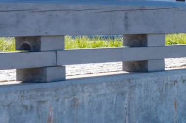 Güneşli bir yaz gününde kaldırımı ve yeşil çimenleri görebileceğiniz ahşap detaylarla dolu beton bir çit. Uzayı kopyala Alıntılar için arka plan. Yüksek kalite fotoğraf