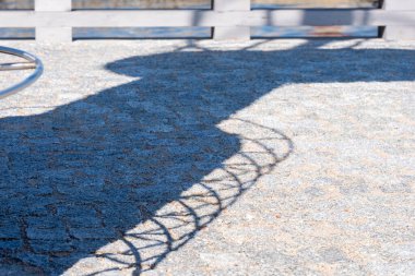 Güneşli bir günde aydınlık kaldırımda ekipmanların gölgesi. Arka planda tahta bir çit var. Uzayı kopyala Alıntılar için arka plan. Yüksek kalite fotoğraf