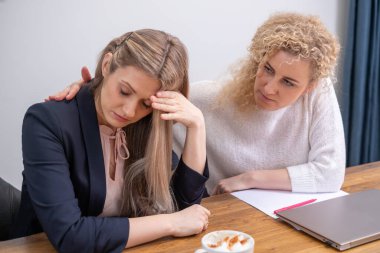 , Bir kadın, empatik bir dinleyicinin karşısında çaresizlik içinde başını tutar. İflasın meydan okumasını ve terapi amaçlı konuşmanın önemli rolünü yakalar. Yüksek kalite fotoğraf