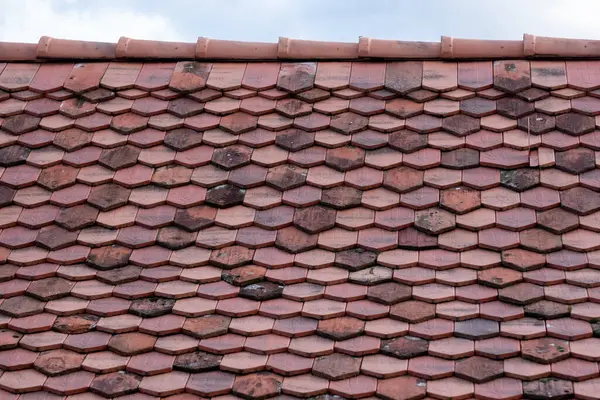 A close-up of a textured red tiled roof showcases traditional craftsmanship and architectural detail symbolizing durability and long-lasting quality in construction. High quality photo