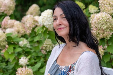 Bir bahçeye, çiçeğe, arka plana karşı durabilen bir kadın, özgüven ve memnuniyet yayar, orta yaşlıları kucaklamanın zarafetini somutlaştırarak kendini sevme ve kabullenme ile mücadele eder. Yüksek kalite fotoğraf