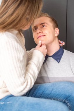 Bir kadın bir erkeğin yüzüne nazikçe dokunur, göz teması derin ve anlayışlı bir bağlantıyı yansıtır, özen ve kapsayıcılığı somutlaştırır. Yüksek kalite fotoğraf