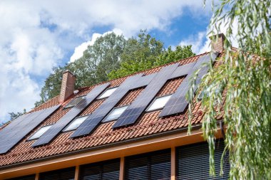 Photovoltaic panels atop a house illustrate the growing adoption of solar energy in urban settings, reflecting a move towards eco sustainability and smart homes. High quality photo clipart