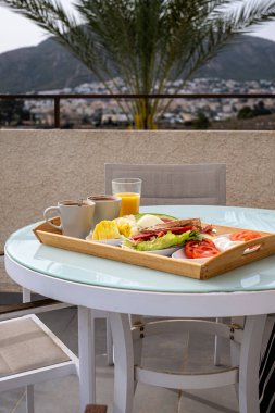 Manzaralı bir dağ manzaralı, sağlıklı bir yemek ve taze meyve suyu, seyahat ve yaşam tarzı temaları için ideal bir çatı üstü kahvaltı düzeneği. Yüksek kalite fotoğraf