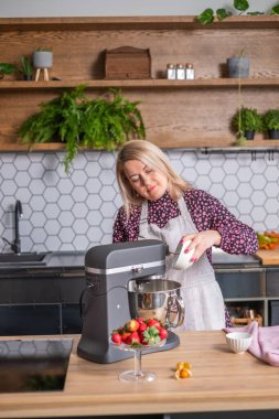 Bir kadın mutfak hazırlığı ve ev yapımı konsepti için karışıma şeker döker.