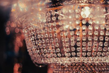 Tavandan sarkan çarpıcı bir kristal avize zenginleştirilmiş iç kısımda sıcak ışık yansımaları oluşturarak büyülü bir ortam yaratıyor..