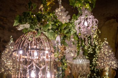 Parlak ışıkları ve yeşilliği olan avizeler çarpıcı bir Noel ağacının etrafına zarif bir şekilde yerleştirilerek bayram neşesiyle dolu şenlikli bir atmosfer yaratılıyor..