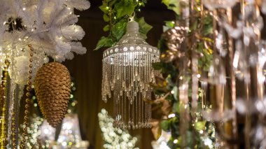 Büyüleyici bir avize parıldayan kristaller ve şenlikli yeşillikler ve büyüleyici ışıklarla çevrili karmaşık tasarımlar, bir tatil ruhunu çağrıştırıyor..