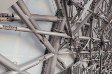 Çelik kirişlerden oluşan karmaşık ağ, büyük kentsel yapılar inşa etmedeki mühendislik becerisini gösteren modern mimari tasarımı vurguluyor..