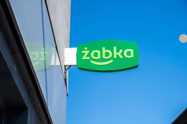 Varşova, Polonya - 10 Temmuz 2025: Zabka mağaza tabelası, kentsel kolaylık ve modern perakende estetiği vurguluyor, açık mavi gökyüzüne çarpıyor
