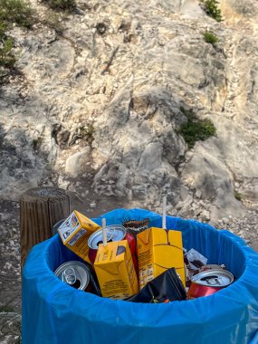 Çöp tenekeleri ve kutular gibi atıklarla dolu çöp kutusu, sorumlu atık yönetimi ve çevresel sürdürülebilirlik ihtiyacını vurguluyor