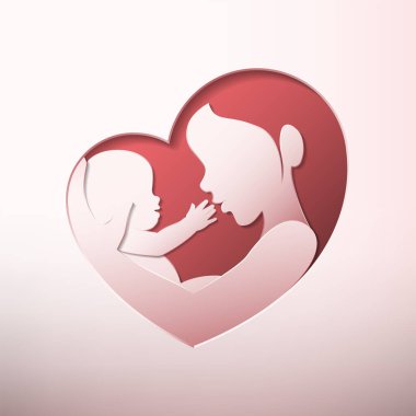 Anne kucağında bir bebek kalp şeklinde siluet kağıdıyla oturmuş sanat eseri kesiyor.
