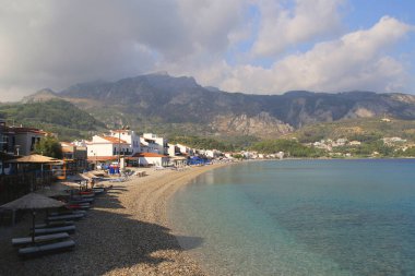 Samos adasındaki geleneksel Yunan balıkçı köyü Kokarri 'de uzun çakıl taşı plajı.