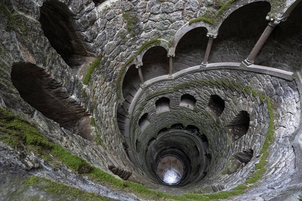 Спиральная лестница в колодце посвящения в мистическом замке Кинта-да-Регалейра, Синтра, Португалия.