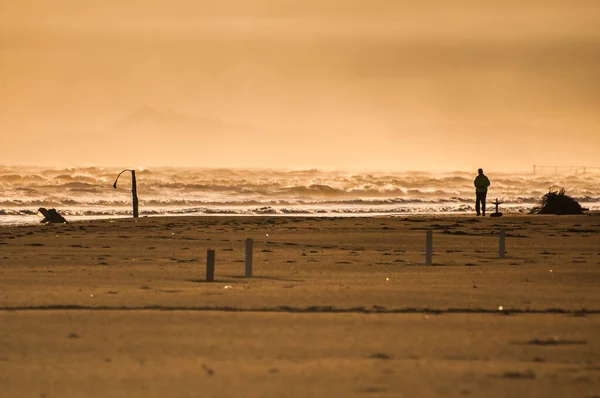 日出时分在海滩上散步的人 — 图库照片