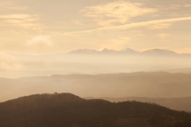 Bulutlu gökyüzü ve dağların dış hatlarının örtüşmesi, hava perspektifi ve dağların dış hatları sis ve bulutlarla kaplı.