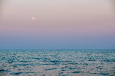 Renkli denizin üzerinde ay doğuyor.