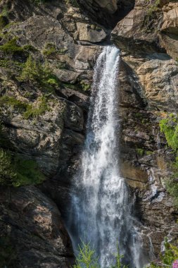 Kayaların arasında akarak Alp Şelalesi oluşturur.
