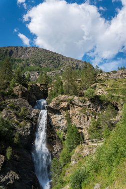Kayaların arasında akarak Alp Şelalesi oluşturur.